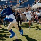 UC Davis Mascot Gunrock leads a group of first-years out onto the football team at halftime in a traditional event called the "Running of the First-years"